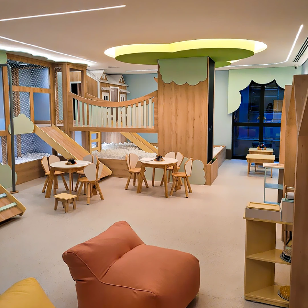 Sala de recreação infantil com brinquedos, escorregadores, mesas e decoração colorida e moderna.